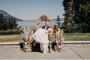 Bride and Groom pose at the wedding venue arbor.