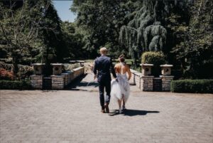 Bride and Groom walk through the property yard.