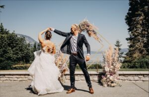 Bride and Groom dancing in front of a wedding Arbor.